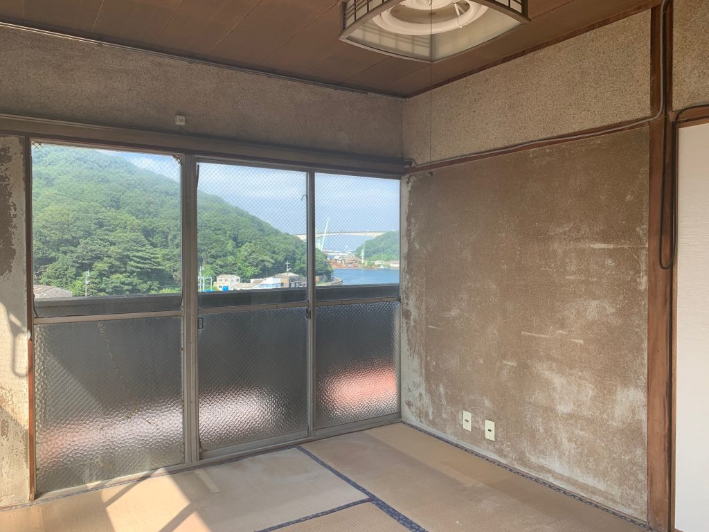 窓から光が差し込む、何もない空き室の内部