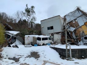 雪の残る道沿いの古い住宅