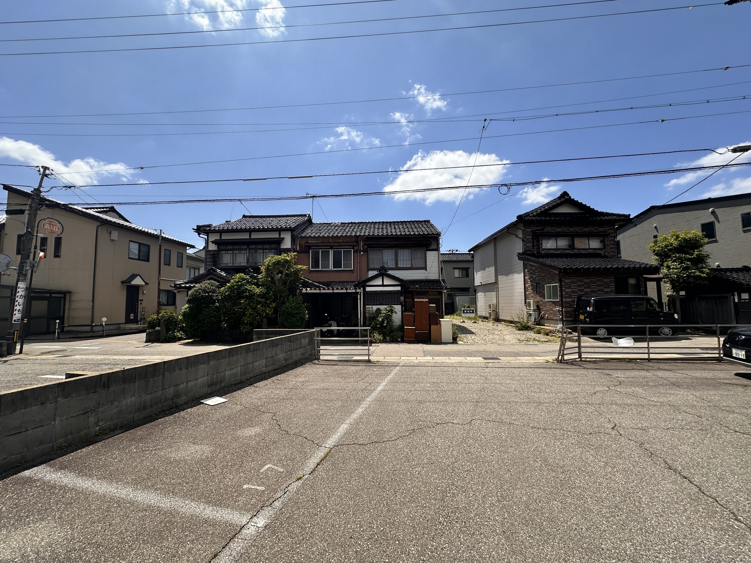 青空の下、住宅が並ぶ静かな住宅街の道路