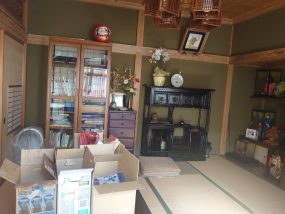 座敷に荷物や段ボールが残された空き家の内部