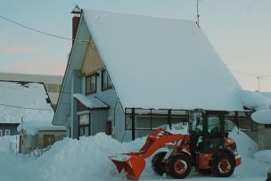 雪に覆われた北海道の住宅と除雪機
